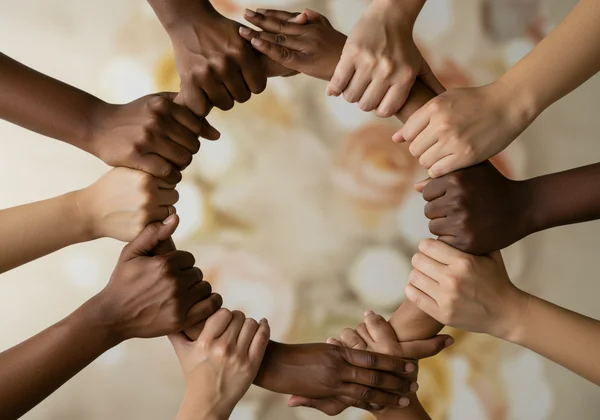 Diverse group of hands interlocking, symbolizing support.